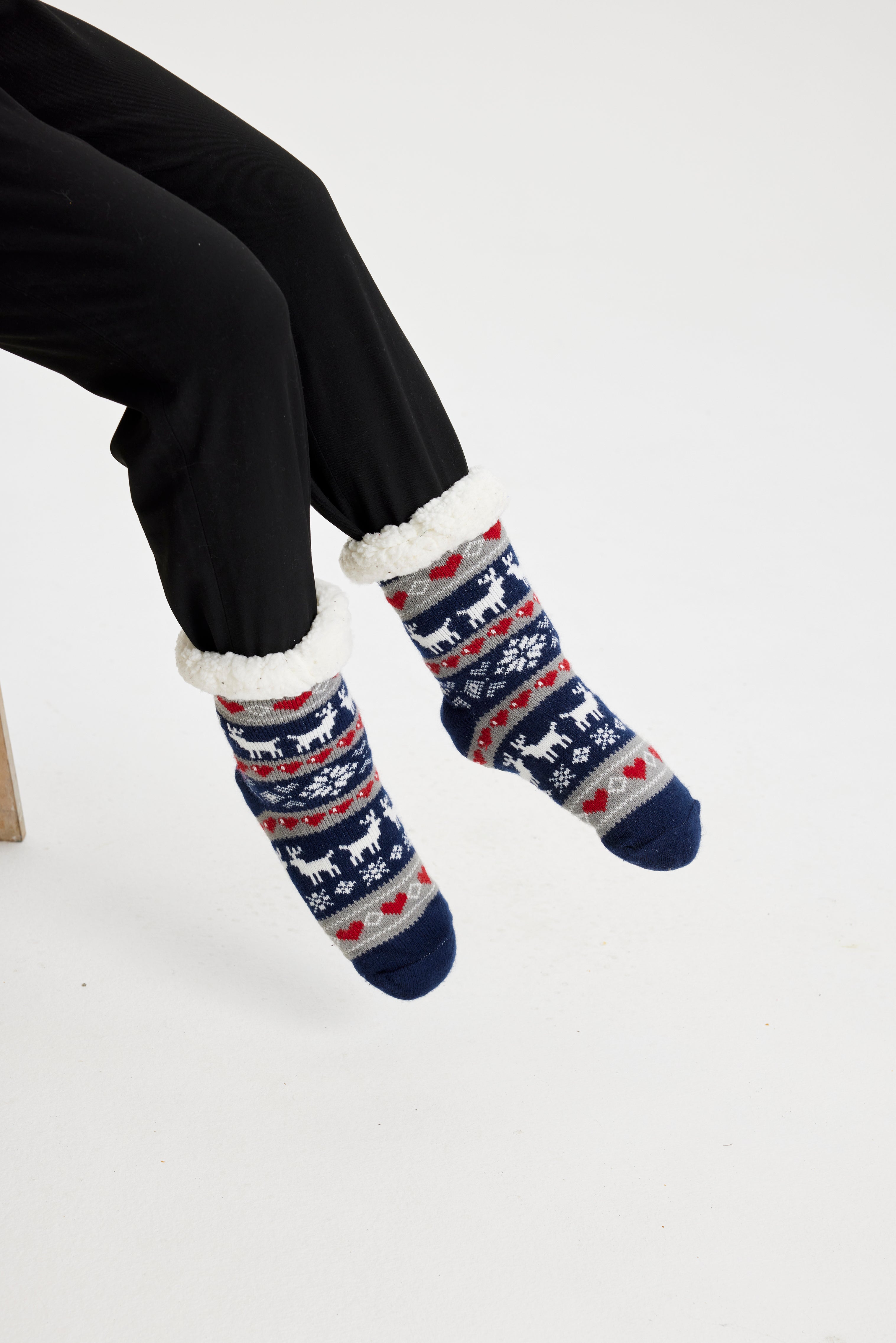 Een paar benen die blauw gestreepte kerstsokken dragen met een patroon erop.